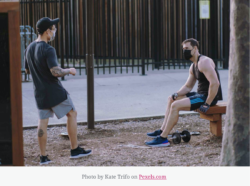 two guys in a park with workout equipment and face masks