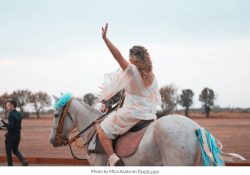 woman on a horse waving goodbye