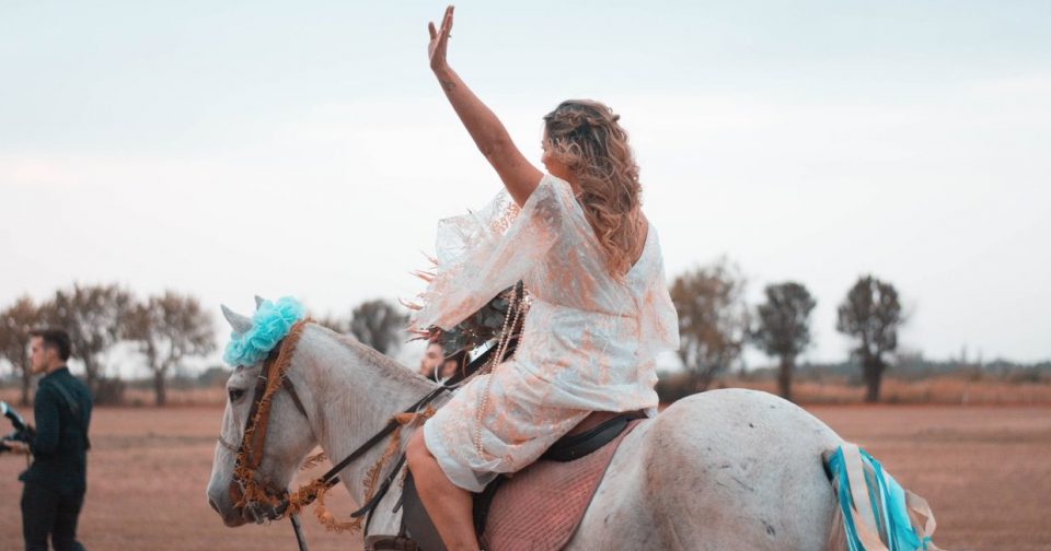 woman on a horse waving goodbye