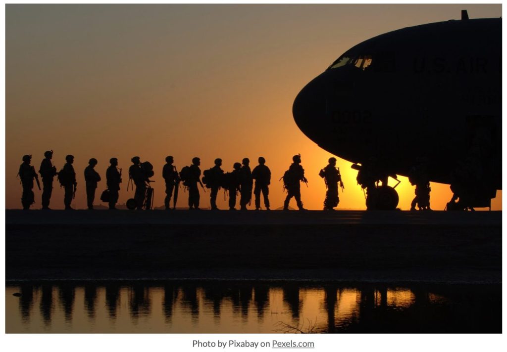 soldiers line up to board a plane